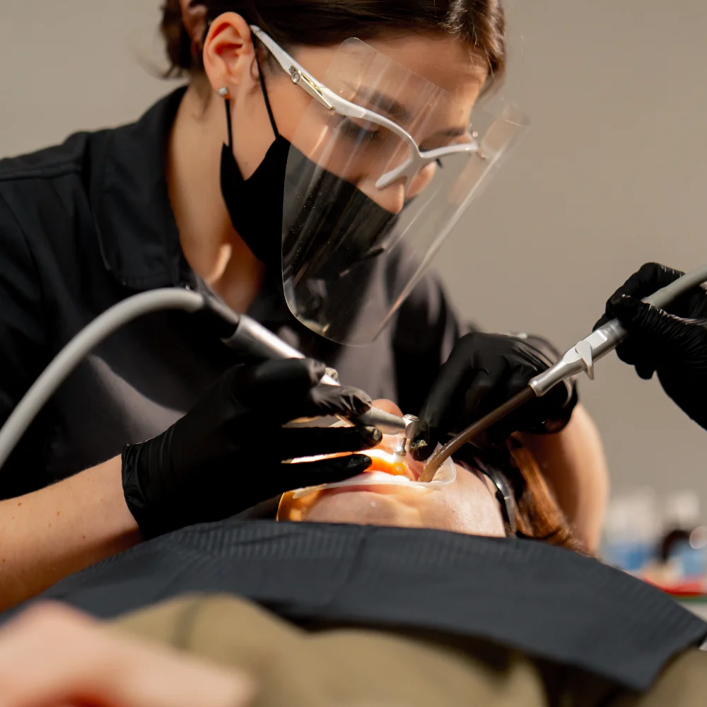 dental-office-girl-dentist-doing-cleaning-to-young-PH3CV7V.webp