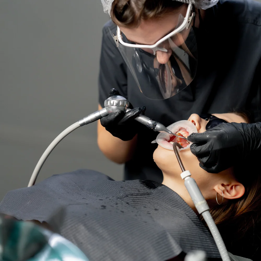 in-a-dental-office-female-dentist-in-a-cap-is-rout-RZH6MZL.webp