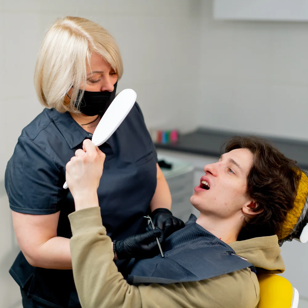 young-man-examined-by-a-caring-dentist-7GUBFME.webp